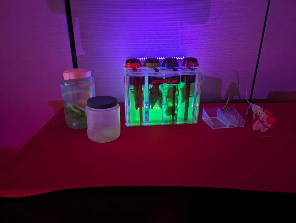 A science-themed display for teas, with glowing test tube container and jars on a desk.